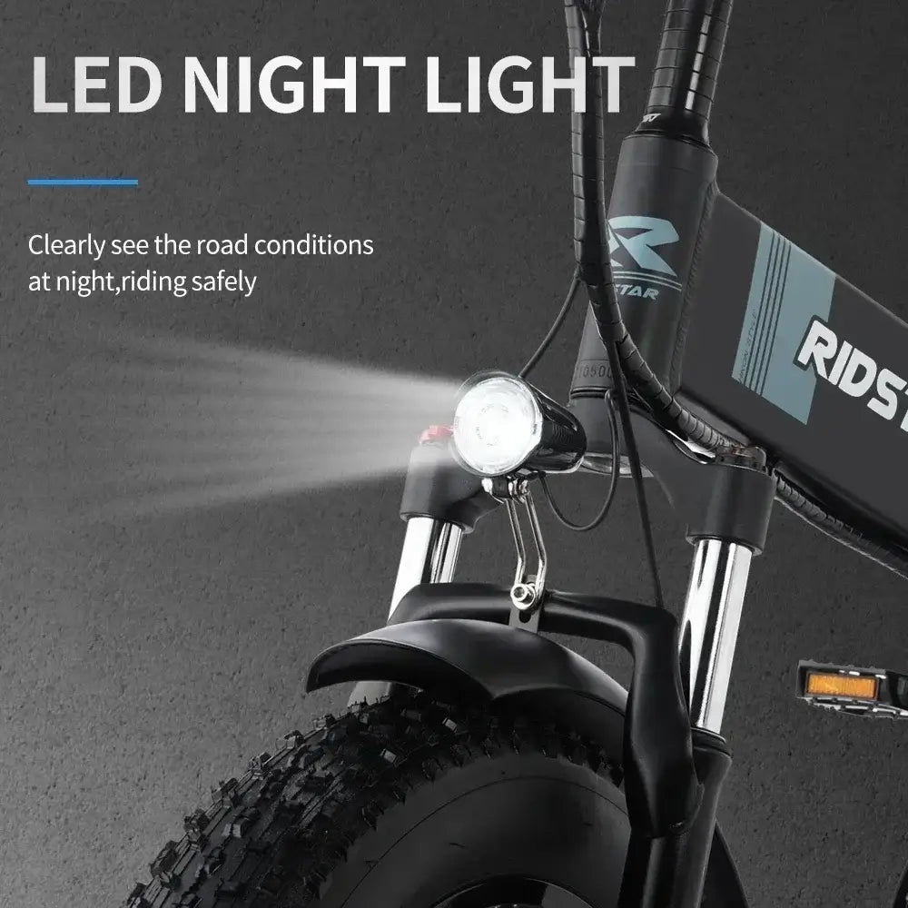 Close-up of LED night light on a folding electric mountain bike for safe night riding.